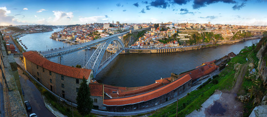 Fototapeta na wymiar Aerial evening wide angle panoramic cityscape. View of the historical part of town Porto. Douro river and the Dom Luis Bridge. Porto. Portugal.