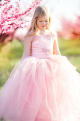 Fototapeta premium Child girl in blooming garden