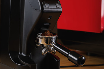 Black electric grinder is on a wooden table