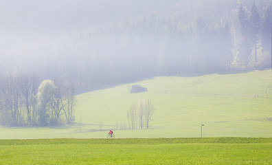 Naklejka na ściany i meble cycling in the misty morning in the alps, good copy space