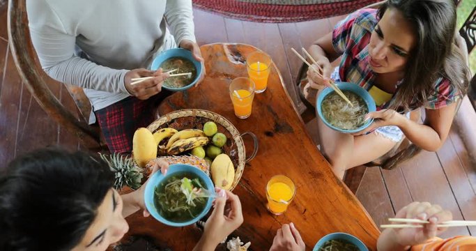 People Eating Delicious Noodles Soup Asian Food, Friends Group Feed Each Other Sit At Table Top Angle View Slow Motion 60
