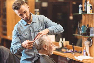 Fashionable hairdresser working in the barbershop