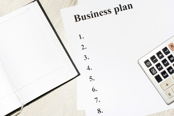 An inscription of the business plan, execution points, there is a notebook and a calculator next to it