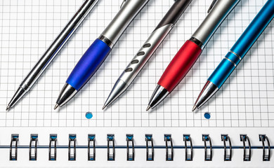 Kolorowe długopisy. Długopisy leżące na notesie.
