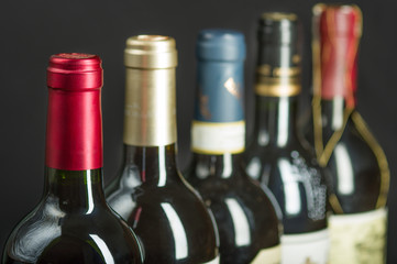 Row of wine bottles with dry red wine. Low depth of field. 