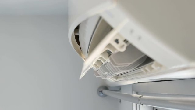 Air conditioner close-up with louver open, showing internal parts, likely during the start-up process for cooling