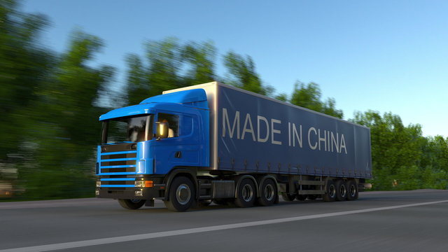 Speeding freight semi truck with MADE IN CHINA caption on the trailer. Road cargo transportation. 3D rendering