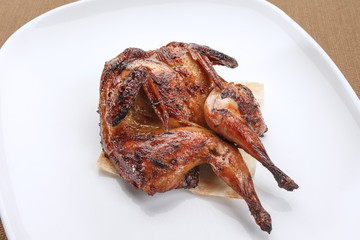 Grilled quail served with pita on a white plate