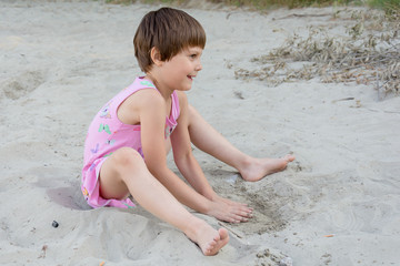 Child play with sand on summer beach