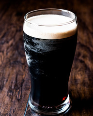 Dark Beer on wooden surface.