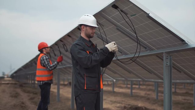 The builders connecting the solar energy panels with the wires.