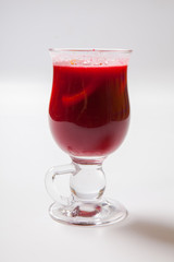 Tall transparent glass with raspberry and citrus tea.