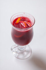 Tall transparent glass with raspberry and citrus tea.