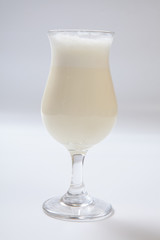 Delicious milkshake with a leaf of mint on top on a white background