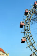 Deurstickers VIENNA, AUSTRIA - MARCH 18, 2016: The red cabin of oldest Ferris Wheel in Prater park on sky background  © inguaribile
