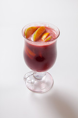 Tall transparent glass with raspberry and citrus tea.