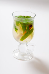 Glass of tea with mint,cinnamon and lime isolated on white
