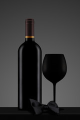 black wine bottle with glass and bow tie