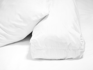 Obraz premium Closeup of white pillow and bolster on bed in bedroom.