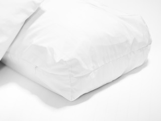 Closeup of white pillow on bed in bedroom.