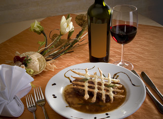 Beautifully arranged plate for dinner with red wine on the table