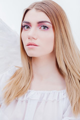 An angel from heaven. Young, wonderful blonde girl in the image of an angel with white wings....