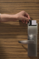 Close up of female hand locking or unlocking the door by inserting keycard in the door electronic...