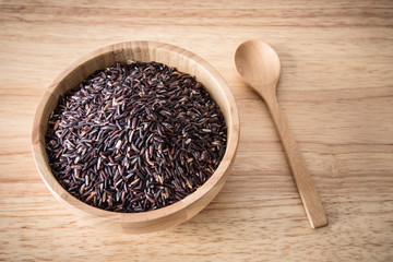 Riceberry in a wooden bowl on wooden background