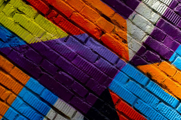 Brick wall with fragment of graffiti, abstract drawings art close-up. For background. Concept of Modern iconic urban culture. Aerosol pictures