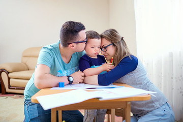 Fototapeta premium A happy family. Mom and dad are hugging their son in the room.