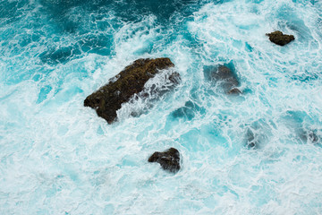 Stones in the azure water of Indian ocean, Indonesia, Bali