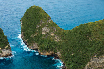 Tropical mountains with green bushes in the azure ocean, Indonesia, Bali