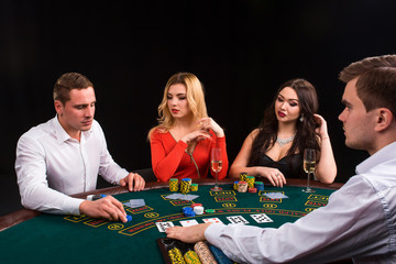 Friends enjoying a gambling night. The dealer deals the cards