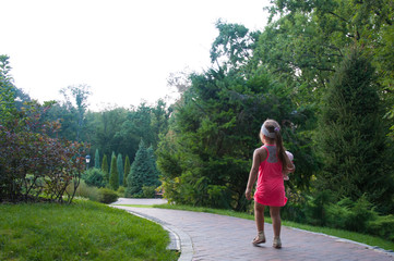 A little girl is walking along the path