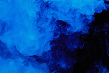 Abstract blue cloud pattern of white smoke on a black background.