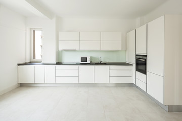 Fototapeta na wymiar White modern kitchen in apartment