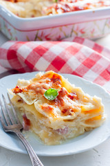 Cut a piece of lasagna with ham, selective focus