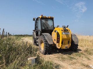 Obraz na płótnie Canvas Tractor through a wheat field