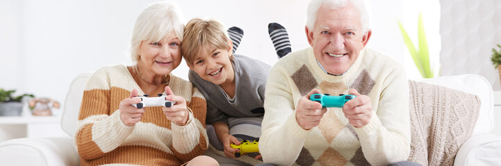 Boy playing video games with grandparents