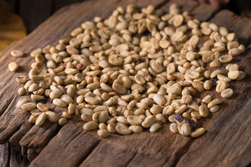 Roasted coffee beans and Green coffee bean on wooden