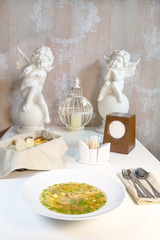 Fish soup in composition with a glass of wine and bread on the table