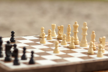Close up wooden chess pieces on board, selective focus on white pieces