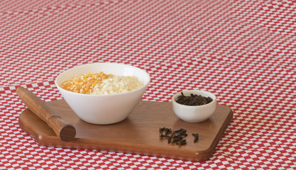 Brazilian dessert sweet canjica of yellow and white dry corn with clove in bowl and towel. Festa Junina Party Brazilian Culture Concept Image. 