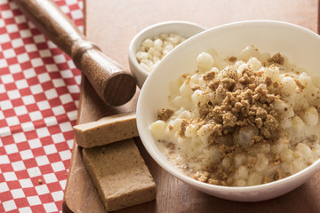 Brazilian dessert sweet canjica of white corn with pacoca sweet in bowl and towel. Festa Junina Party Brazilian Culture Concept Image.