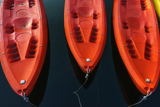 Red kayaks on dark blue water