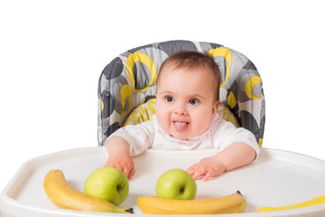 Fototapeta premium little child girl sitting at table with fruits isolated