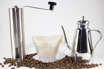 Coffee dripper and pot with coffee grinder on white background