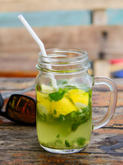 Mojito coctail on a wooden table in front of the sea.