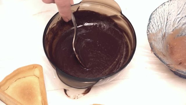 Woman's hands mixing the syrup and the hot chokolate in the glass bowl