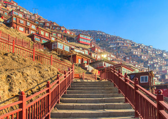 Red monastery at Larung gar (Buddhist Academy) in sunshine day and background is blue sky, Sichuan,...